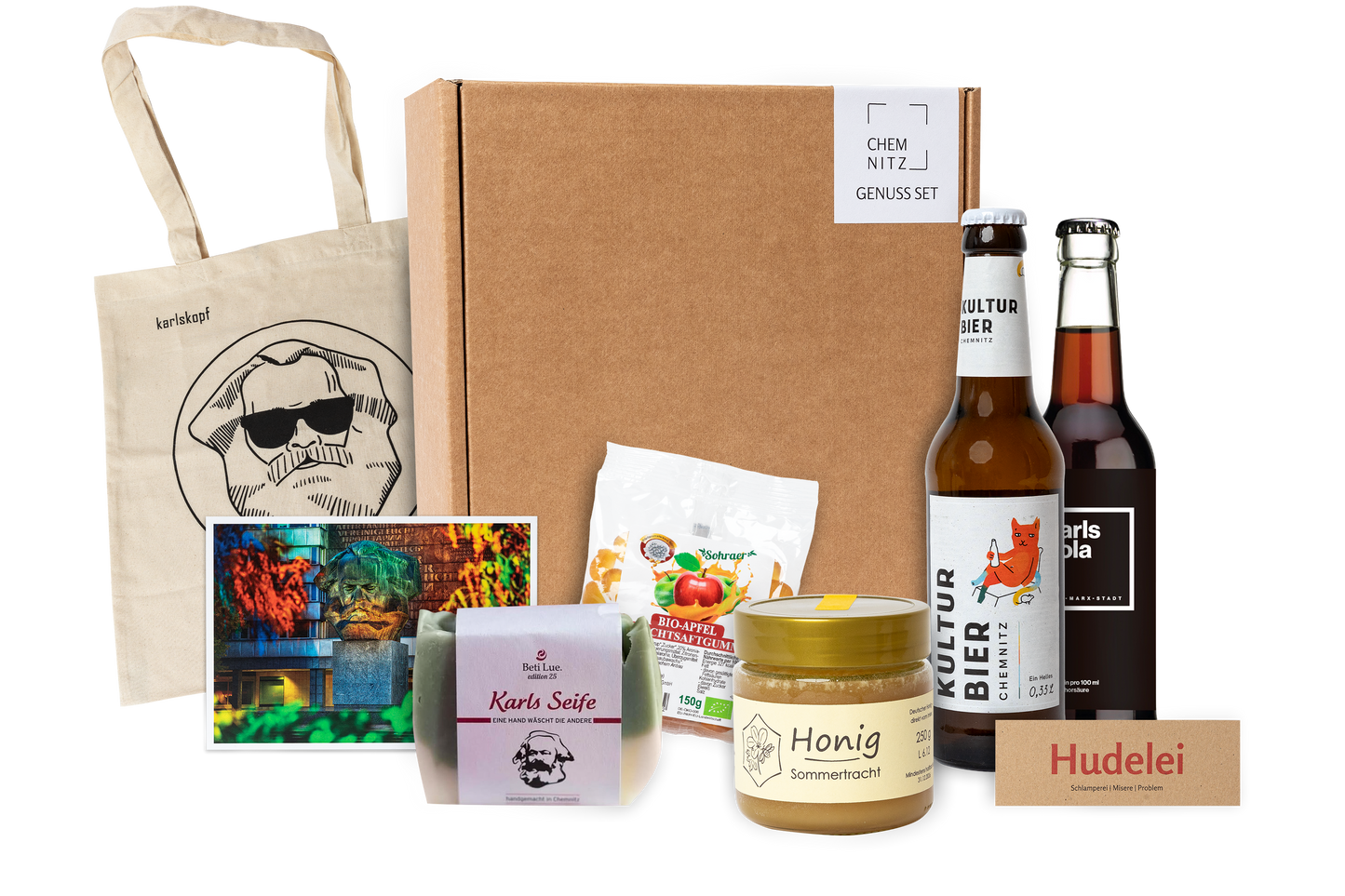 Genuss Set Chemnitz Basis mit Baumwolltasche mit Karlskopf-Logo, Karls Seife, Bio-Fruchtsaftgummi, Honig, Karls Kola Flasche, Kulturbier Flasche in braunem Karton.