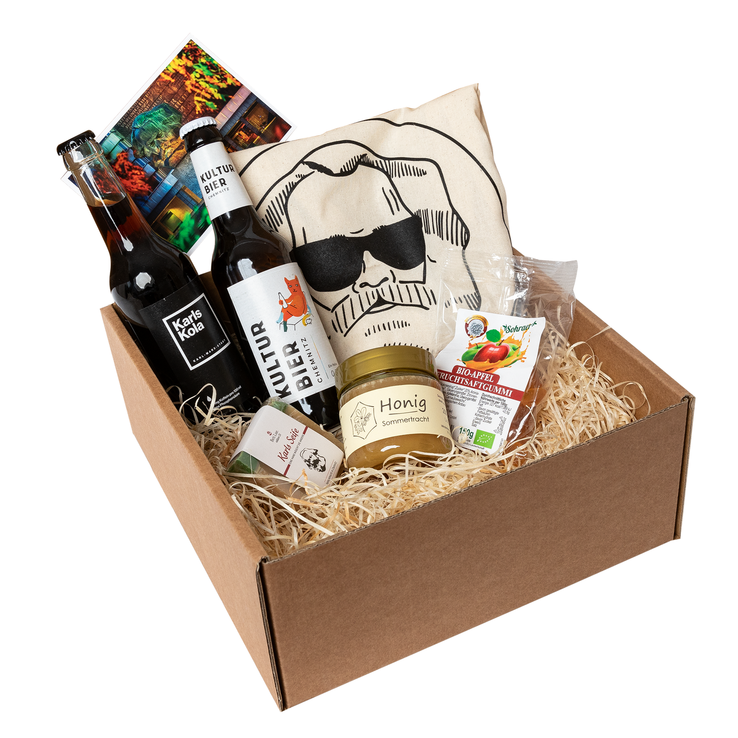 Genuss Set Chemnitz Basis mit Baumwolltasche mit Karlskopf-Logo, Karls Seife, Bio-Fruchtsaftgummi, Honig, Karls Kola Flasche, Kulturbier Flasche in braunem Karton.