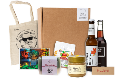 Genuss Set Chemnitz Basis mit Baumwolltasche mit Karlskopf-Logo, Karls Seife, Bio-Fruchtsaftgummi, Honig,  Karls Kola Flasche, Kulturbier Flasche in braunem Karton.