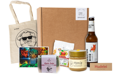 Genuss Set Chemnitz Basis mit Baumwolltasche mit Karlskopf-Logo, Karls Seife, Bio-Fruchtsaftgummi, Honig, Kulturbier Flasche in braunem Karton.