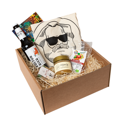 Genuss Set Chemnitz Basis mit Baumwolltasche mit Karlskopf-Logo, Karls Seife, Bio-Fruchtsaftgummi, Honig, Kulturbier Flasche in braunem Karton.